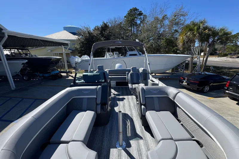 Slide: The Image of 2026 Bennington 22 MSB pontoon boat with spacious seating, parked outdoors under clear skies. - 17