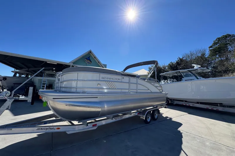 Slide: The Image of 2026 Bennington 22 MSB pontoon boat on trailer under bright sun. - 3