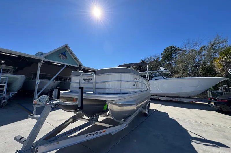 Slide: The Image of 2026 Bennington 22 MSB pontoon boat on trailer under clear blue sky. - 4
