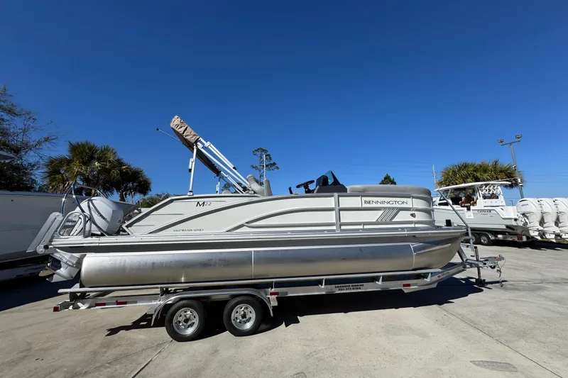Slide: The Image of 2026 Bennington 22 MSB pontoon boat on trailer under clear blue sky. - 9