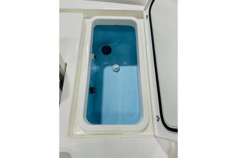 Slide: The Image of Livewell compartment in 2026 Pathfinder 2600 TRS boat, featuring a blue interior. - 16