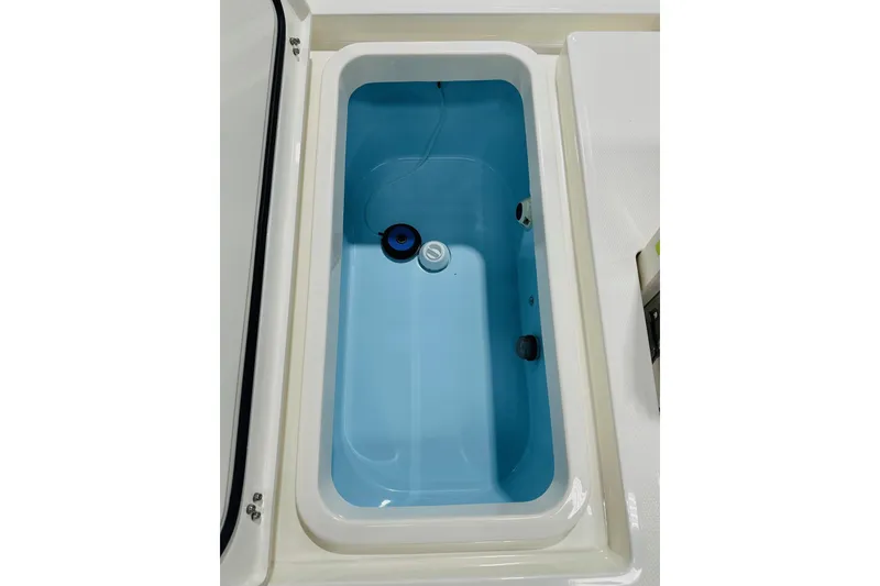 Slide: The Image of Livewell compartment in 2026 Pathfinder 2600 TRS boat, featuring a clean, blue interior. - 17