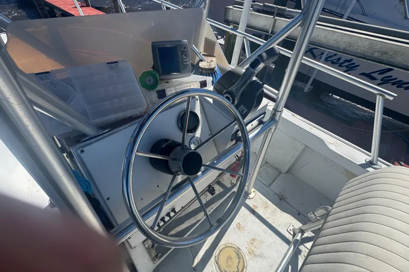 Slide: The Image of 1988 Boston Whaler Outrage 17 boat helm with steering wheel and navigation equipment. - 13