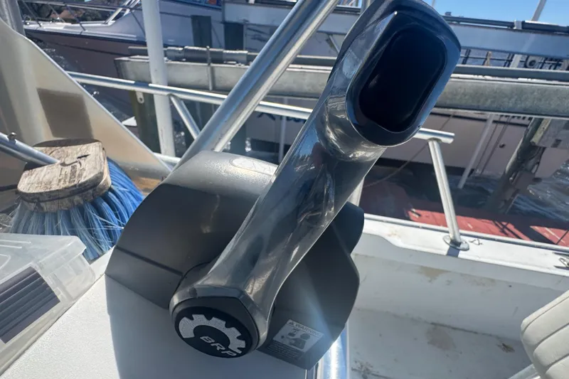 Slide: The Image of Throttle control on a 1988 Boston Whaler Outrage 17 boat, docked with cleaning supplies nearby. - 14