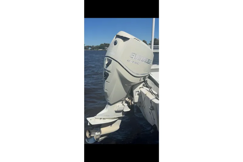 Slide: The Image of 1988 Boston Whaler Outrage 17 with Evinrude E-TEC outboard motor on water. - 23