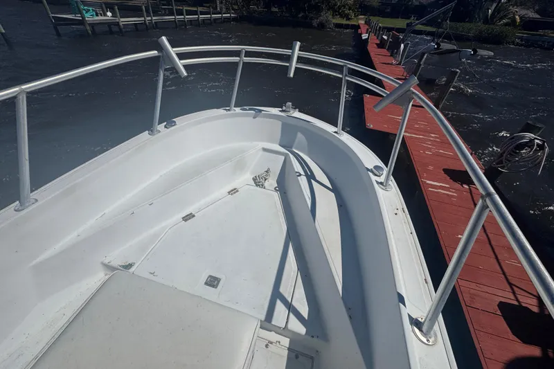 Slide: The Image of 1988 Boston Whaler Outrage 17 boat docked, featuring a clean white deck and railing. - 3