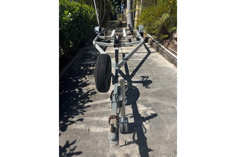 Slide: The Image of Empty boat trailer for 1988 Boston Whaler Outrage 17 on a driveway. - 35