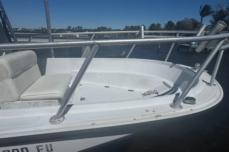 Slide: The Image of 1988 Boston Whaler Outrage 17 boat with seating and railing, docked on a sunny day. - 5