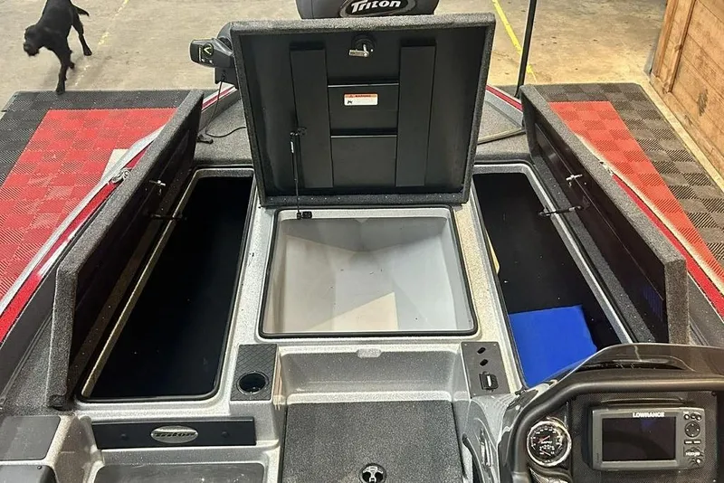 Slide: The Image of 2019 Triton 18 TrX boat interior with open storage compartments and control panel. - 3