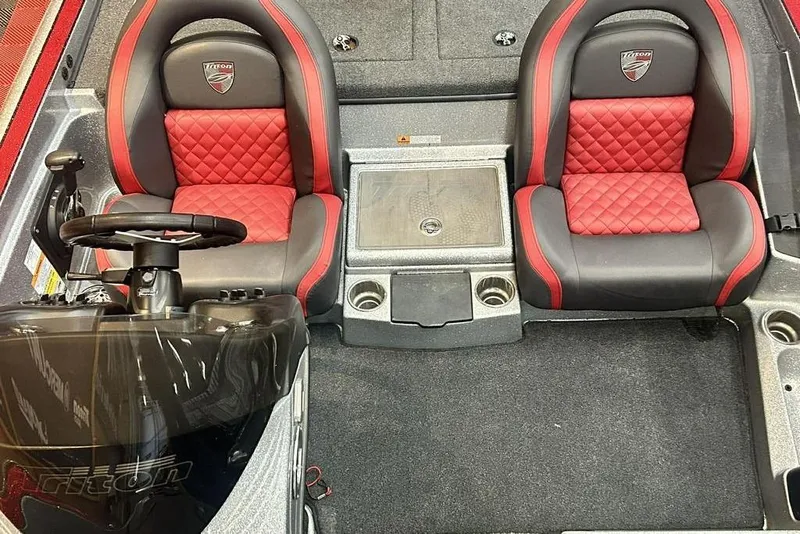 Slide: The Image of 2019 Triton 18 TrX boat interior with red and black seats, steering wheel, and console. - 8