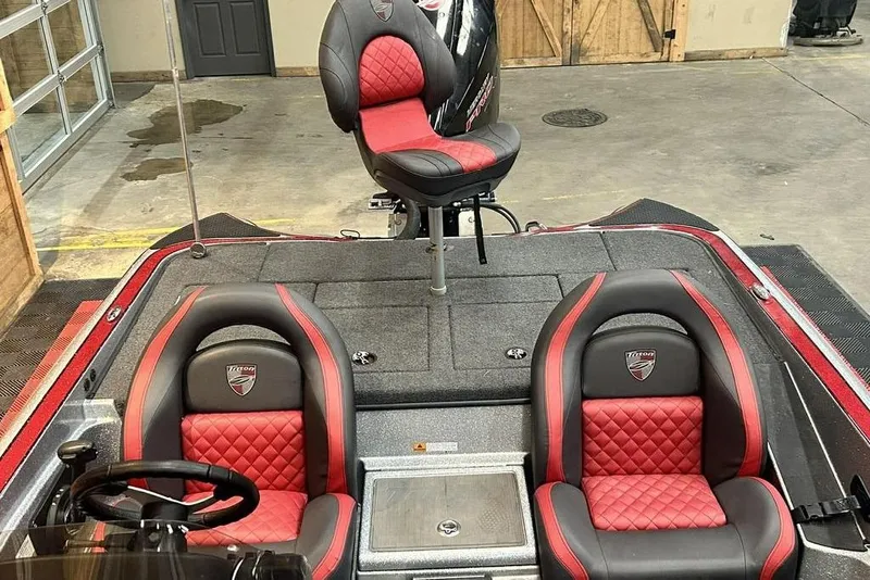 Slide: The Image of 2019 Triton 18 TrX boat interior with red and black seats in a showroom. - 9