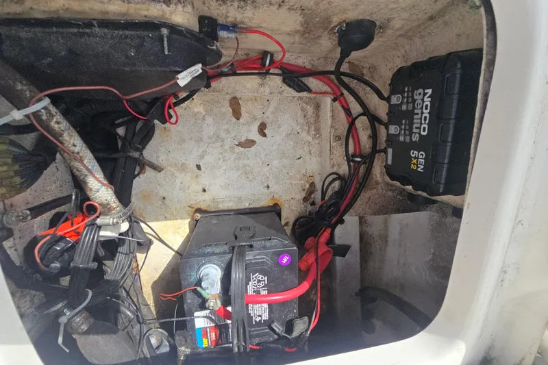 Slide: The Image of Battery compartment of 2012 Everglades 243 Center Console with wiring and NOCO Genius charger. - 19