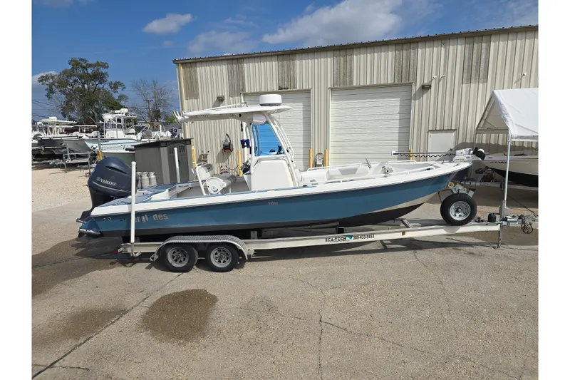Slide: The Image of 2012 Everglades 243 Center Console boat on trailer, parked outdoors. - 2