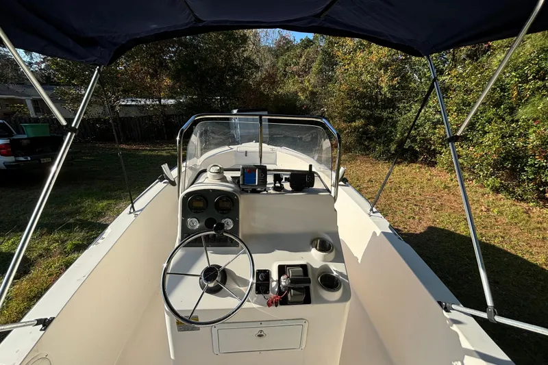 Slide: The Image of 2005 Sea Hunt Triton 202 boat interior with steering wheel and dashboard, under canopy. - 12