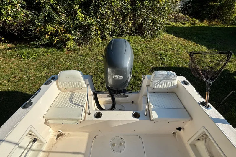 Slide: The Image of 2005 Sea Hunt Triton 202 boat with Yamaha 150 engine, white seating, and fishing net. - 13
