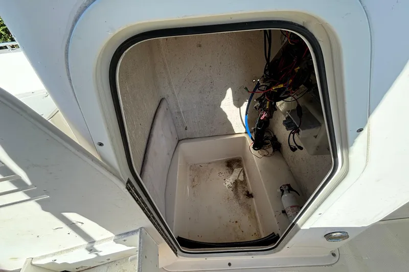 Slide: The Image of 2005 Sea Hunt Triton 202 boat storage compartment with wiring and fire extinguisher. - 16