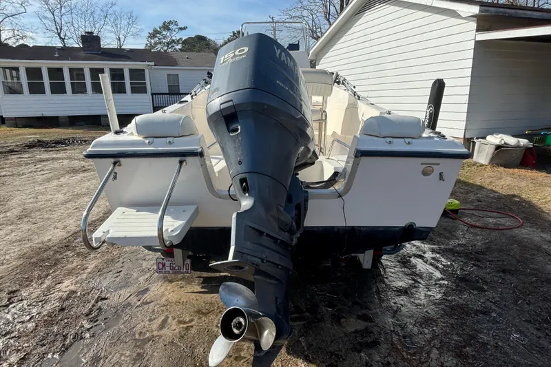 Slide: The Image of 2005 Sea Hunt Triton 202 boat with Yamaha 150 outboard motor, parked outdoors. - 8