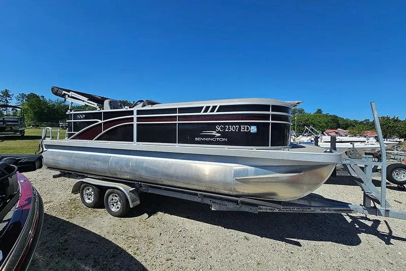Slide: The Image of 2023 Bennington 21 SLX pontoon boat on trailer under clear blue sky. - 11