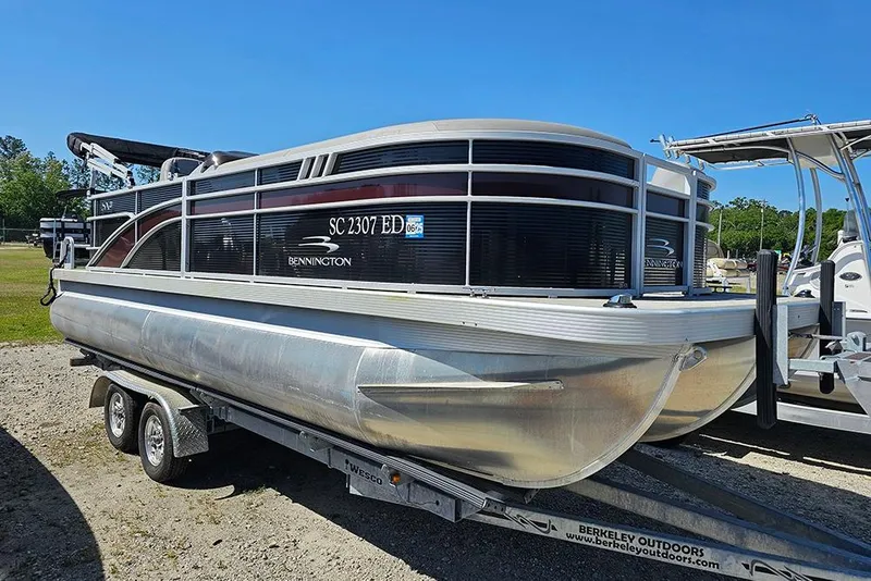 Slide: The Image of 2023 Bennington 21 SLX pontoon boat on trailer, parked outdoors. - 12