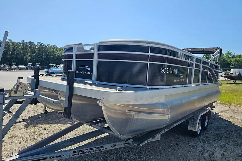 Slide: The Image of 2023 Bennington 21 SLX pontoon boat on trailer in outdoor setting. - 16