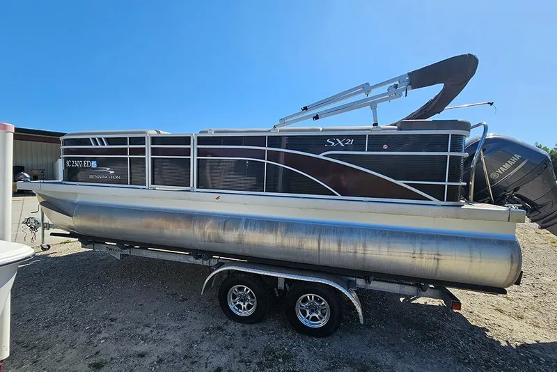 Slide: The Image of 2023 Bennington 21 SLX pontoon boat on trailer, featuring Yamaha outboard motor. - 17