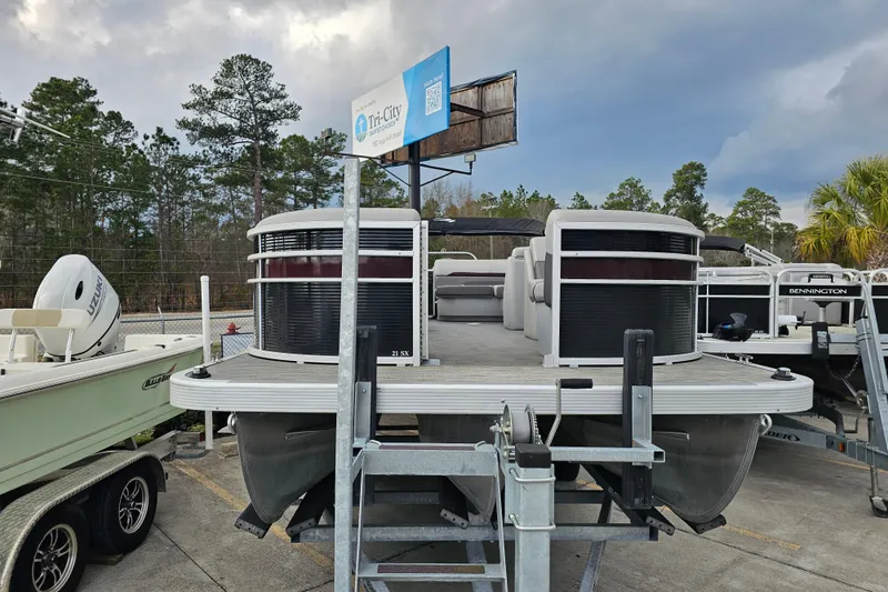 Slide: The Image of 2023 Bennington 21 SLX pontoon boat displayed outdoors on a trailer. - 3
