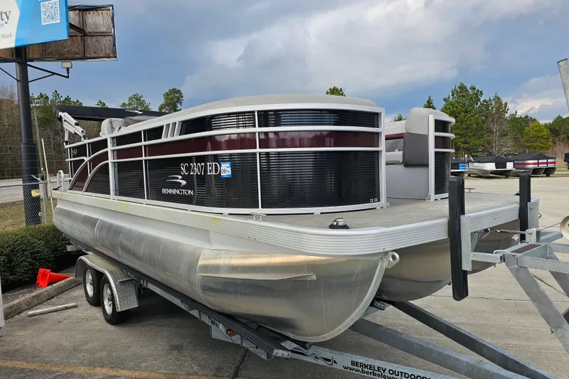 Slide: The Image of 2023 Bennington 21 SLX pontoon boat on trailer, parked outdoors. - 4