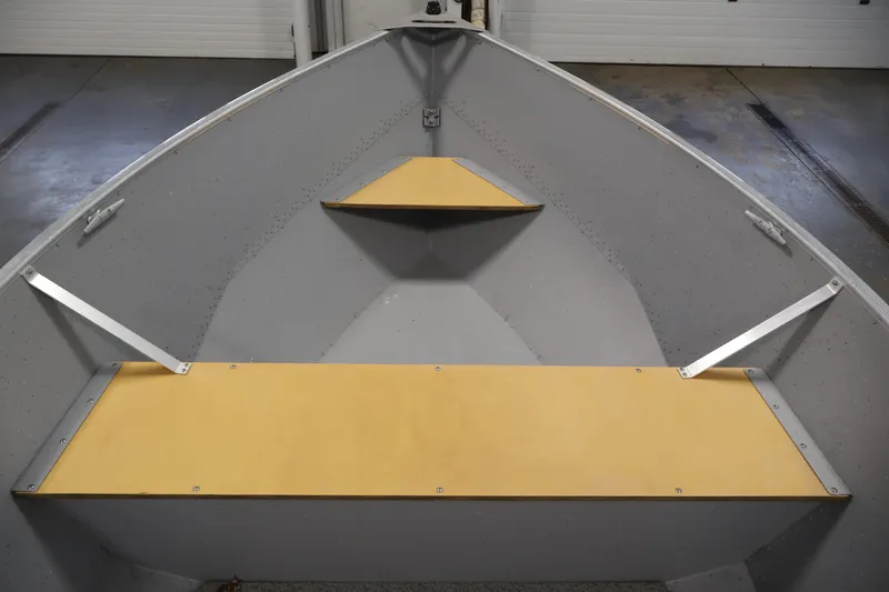 Slide: The Image of 2022 Lund SSV-16 Tiller boat interior with wooden seats and metal supports. - 11