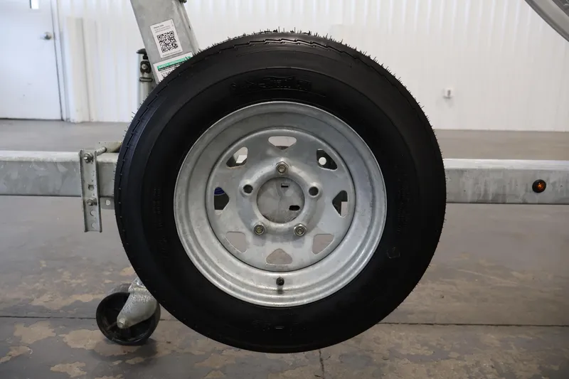 Slide: The Image of Trailer wheel of 2022 Lund SSV-16 Tiller boat in a garage setting. - 25