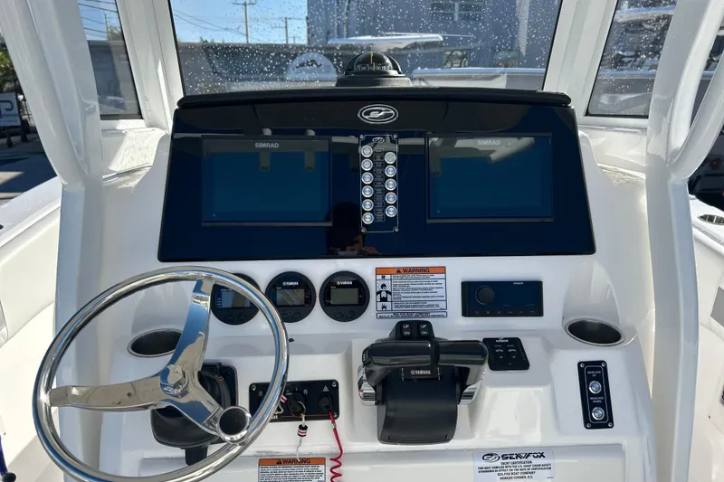 Slide: The Image of 2024 Sea Fox 268 Commander dashboard with steering wheel, controls, and Simrad displays. - 15