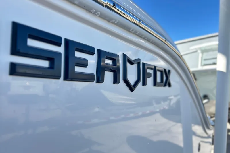 Slide: The Image of 2024 Sea Fox 268 Commander boat logo on white hull, close-up view. - 27