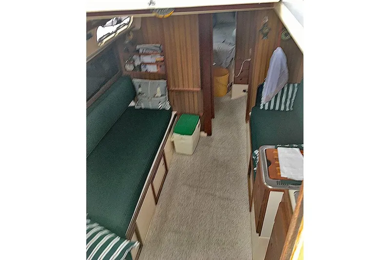Slide: The Image of Interior of 1975 Mirage Yachts 27, featuring green seating and wooden paneling. - 4