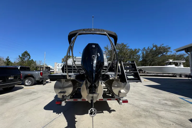 Slide: The Image of 2026 Bennington 22 MSB pontoon boat on trailer, parked outdoors under clear blue sky. - 12