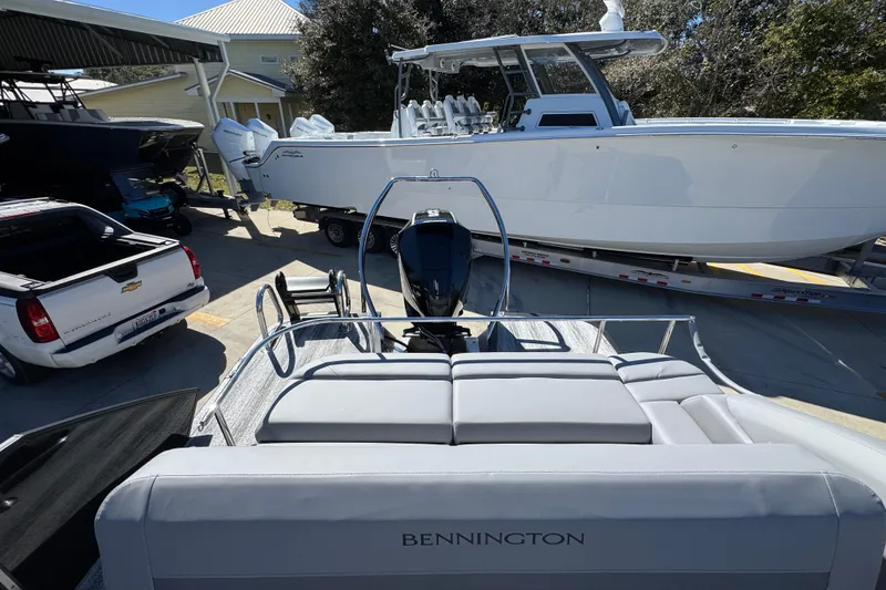 Slide: The Image of 2026 Bennington 22 MSB pontoon boat in a marina, surrounded by other boats and vehicles. - 28