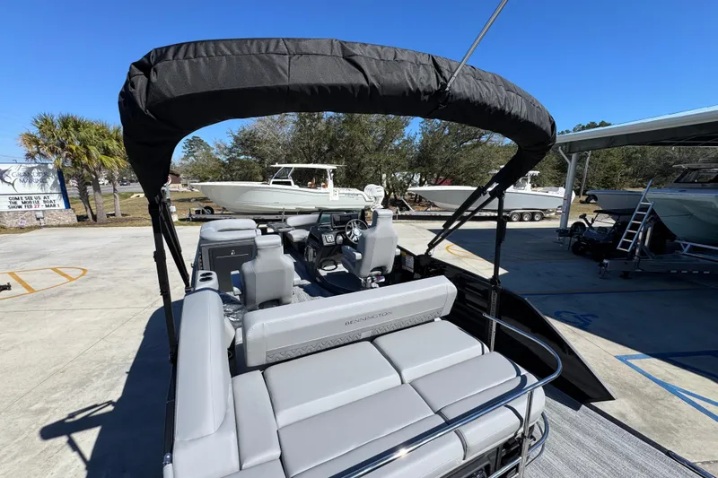 Slide: The Image of 2026 Bennington 22 MSB pontoon boat with canopy, parked outdoors under clear blue sky. - 30