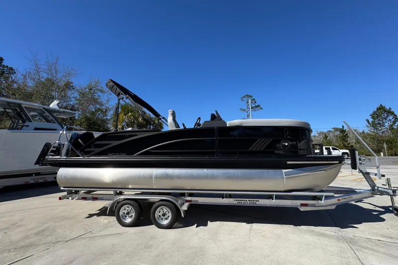 Slide: The Image of 2026 Bennington 22 MSB pontoon boat on trailer under clear blue sky. - 8