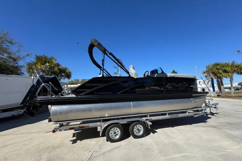 Slide: The Image of 2026 Bennington 22 MSB pontoon boat on trailer, parked outdoors under clear blue sky. - 9