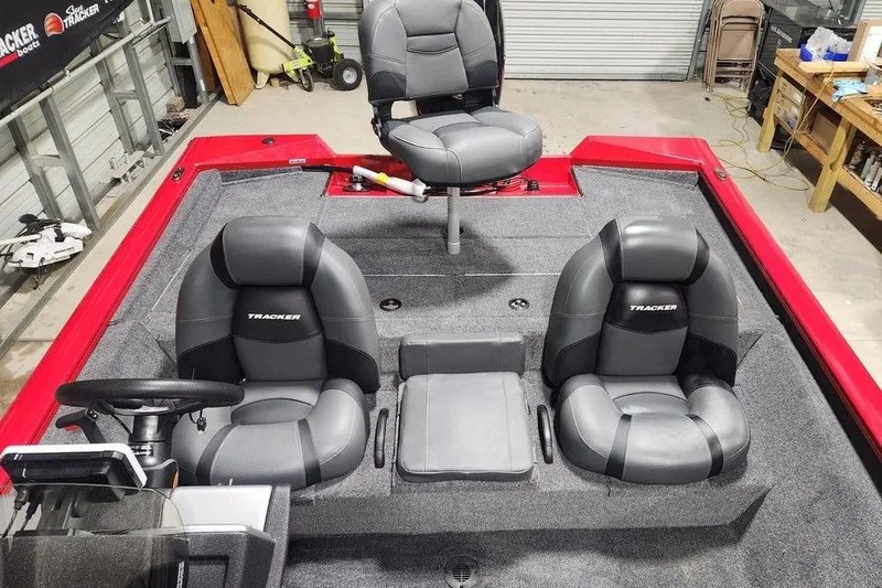 Slide: The Image of 2026 Tracker Pro Team 195 boat interior with three gray seats in a garage setting. - 9
