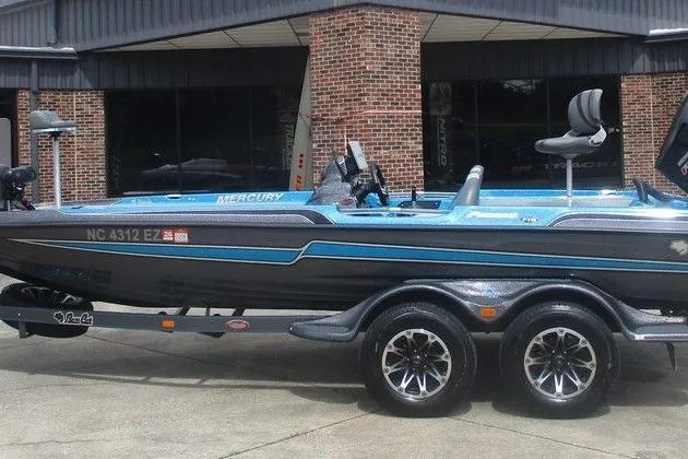Slide: The Image of 2020 Bass Cat Puma FTD boat on trailer, parked outside a brick building. - 1
