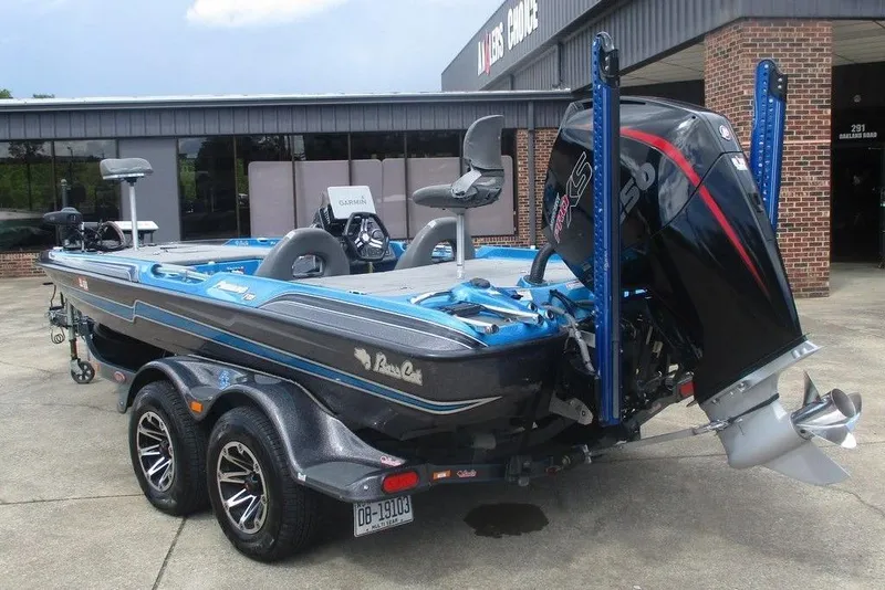 Slide: The Image of 2020 Bass Cat Puma FTD boat with powerful engine, parked outside a building. - 2
