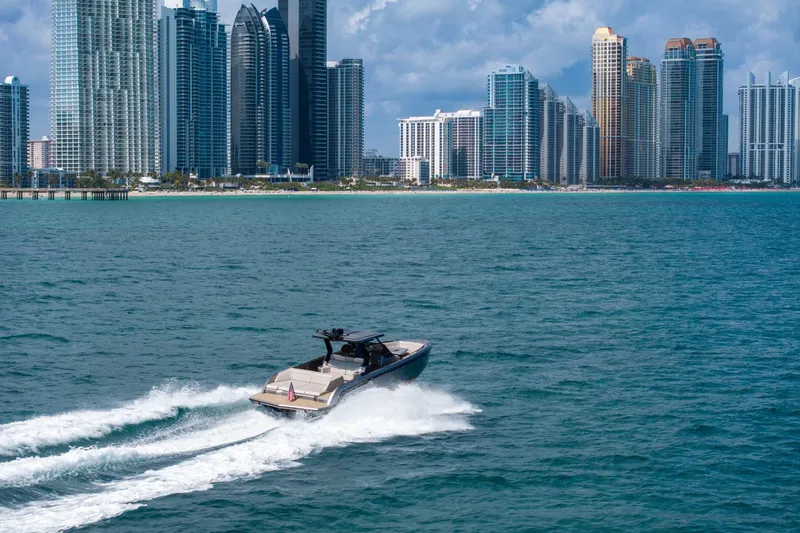 Slide: The Image of 2022 Vanquish VQ40 yacht cruising near city skyline, blue ocean waters. - 11