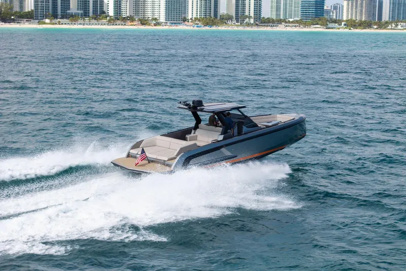 Slide: The Image of 2022 Vanquish VQ40 yacht cruising near a city skyline on open water. - 2