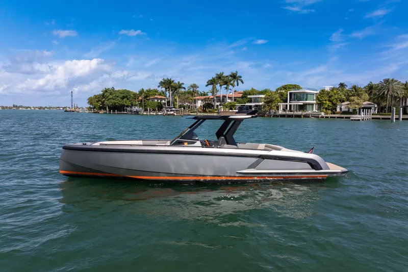 Slide: The Image of 2022 Vanquish VQ40 luxury yacht cruising on a sunny day near waterfront homes. - 4