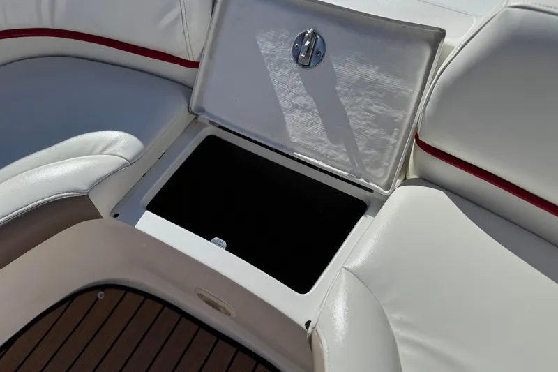 Slide: The Image of Open storage compartment on 2004 Cobalt 240SD boat with white seating and red trim. - 16