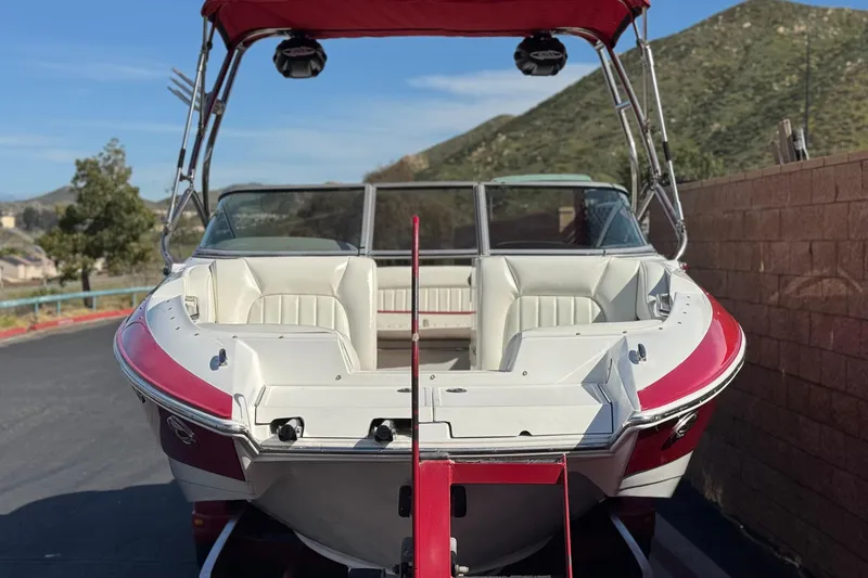 Slide: The Image of 2004 Cobalt 240SD boat with red accents, parked outdoors near mountains. - 2