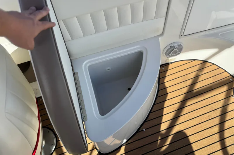 Slide: The Image of 2004 Cobalt 240SD boat interior with open storage compartment and wooden deck. - 24