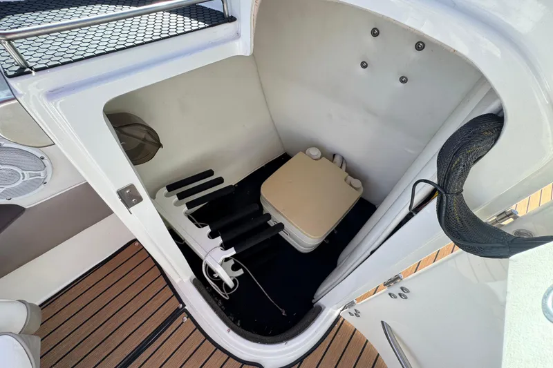 Slide: The Image of 2004 Cobalt 240SD boat interior with portable toilet and storage area. - 31