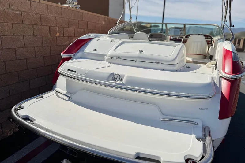 Slide: The Image of 2004 Cobalt 240SD boat with white and red exterior, docked near a brick wall. - 6