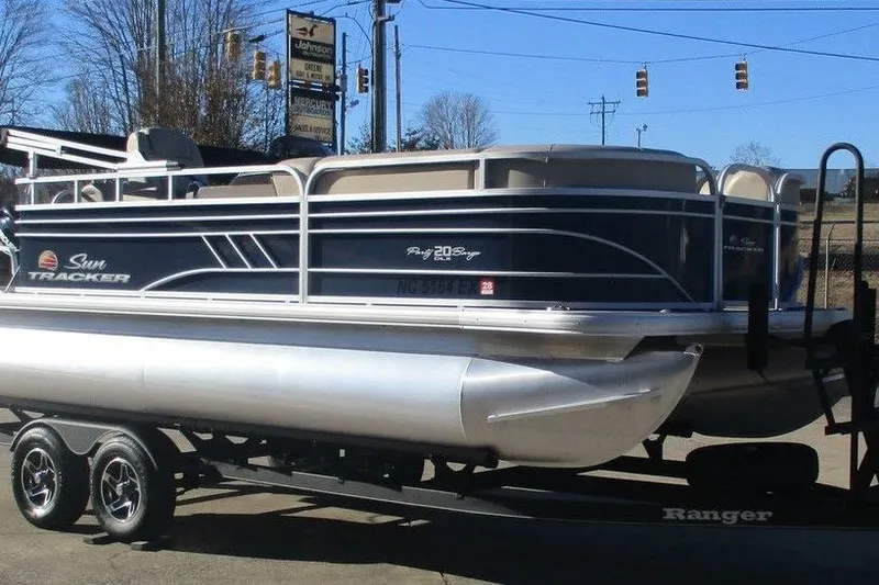 Slide: The Image of 2022 Sun Tracker Party Barge 20 DLX pontoon boat on trailer, parked outdoors. - 3