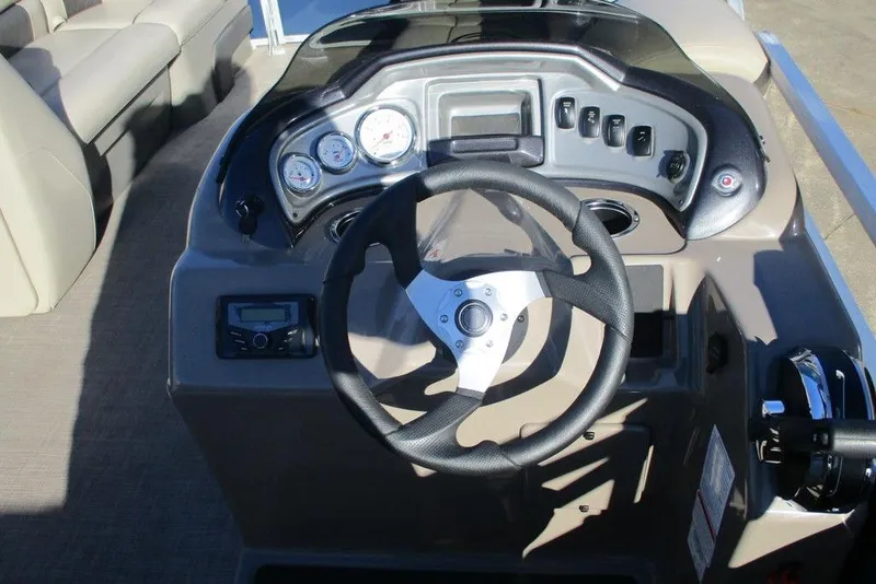 Slide: The Image of 2022 Sun Tracker Party Barge 20 DLX dashboard with steering wheel and control panel. - 8